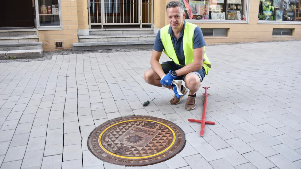 Det nya brunnslocket pryds av kommunvapnet. Pilarna på sidorna pekar mot stället där man ska öppna, det behövs när det är is, grus eller lera på locket.  