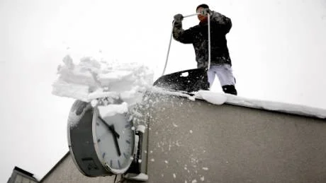 Kamp mot klockan. Muraren Tomas Smedberg är en av tio hantverkare som sedan i fredags fått byta handverktyg mot snöslädar, för att rensa det gigantiska taket på gamla Flextronicshuset från snö, innan det kommer ännu mer.Foto: Henrik Radhe
