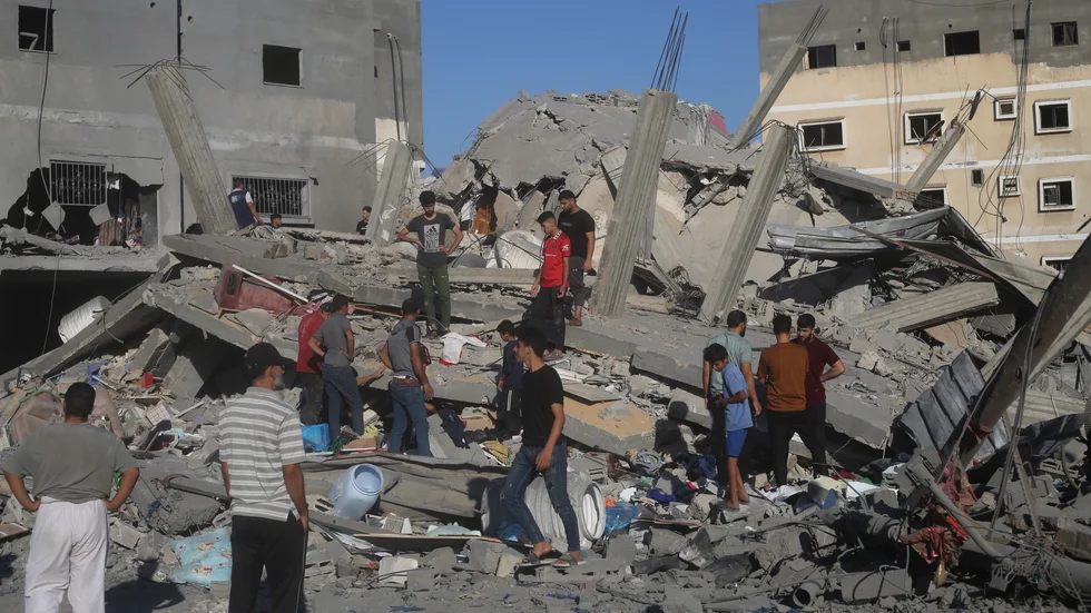 En byggnad som förstördes i Rafah i södra Gaza under natten till lördag. Palestinier letar efter överlevande.