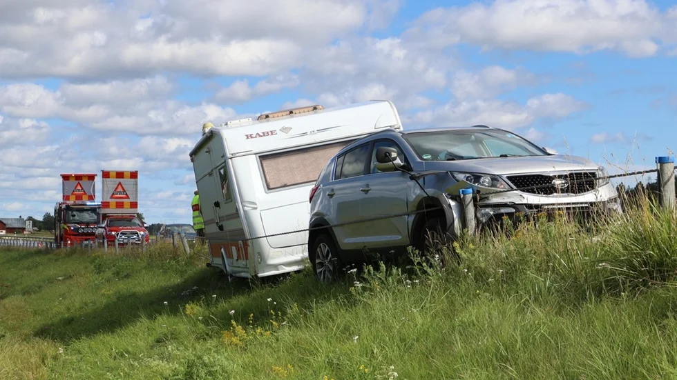 En bil med husvagn har kört in i räcket på väg 288 i Alunda och fastnat. 