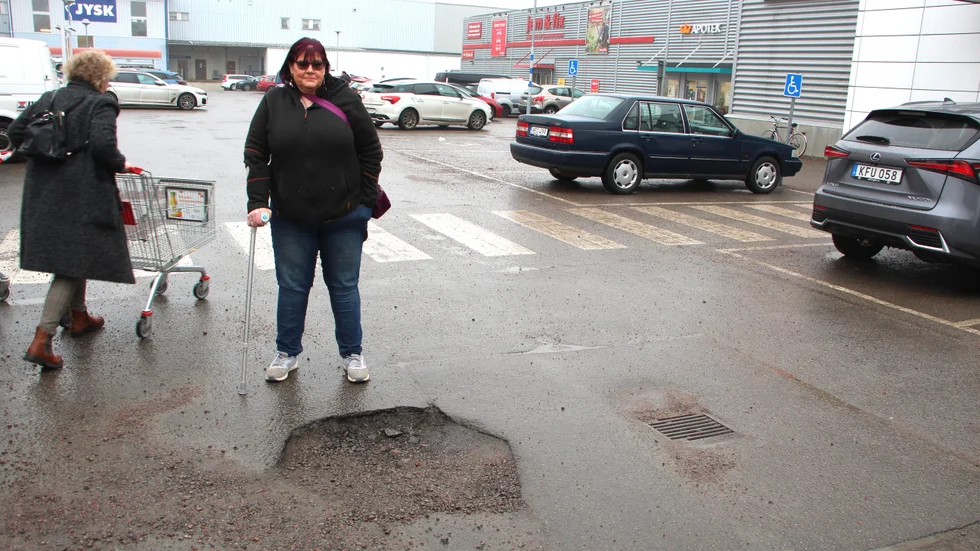 Margitha Karlsson vid hålet hon trampade snett i januari. Efter att det fylldes igen efter olyckan, är det på nytt lika illa.