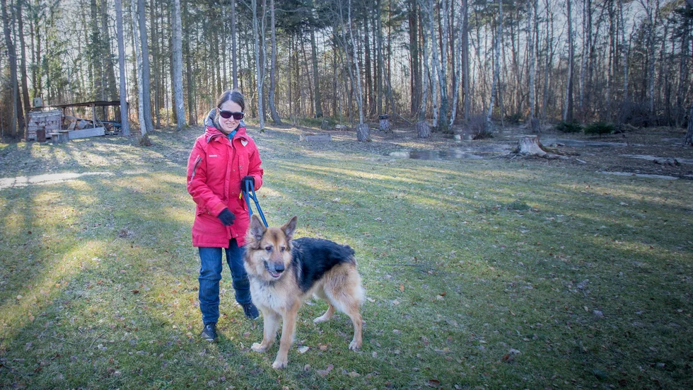 Victoria Öjefors Quinn tillsammans med sin hund intill bostaden i Västerhejde, ett gårdshus som hon får hyra fram till sommaren. Utan färdtjänst har hon troligtvis inget val annat än att flytta till Visby, säger hon.