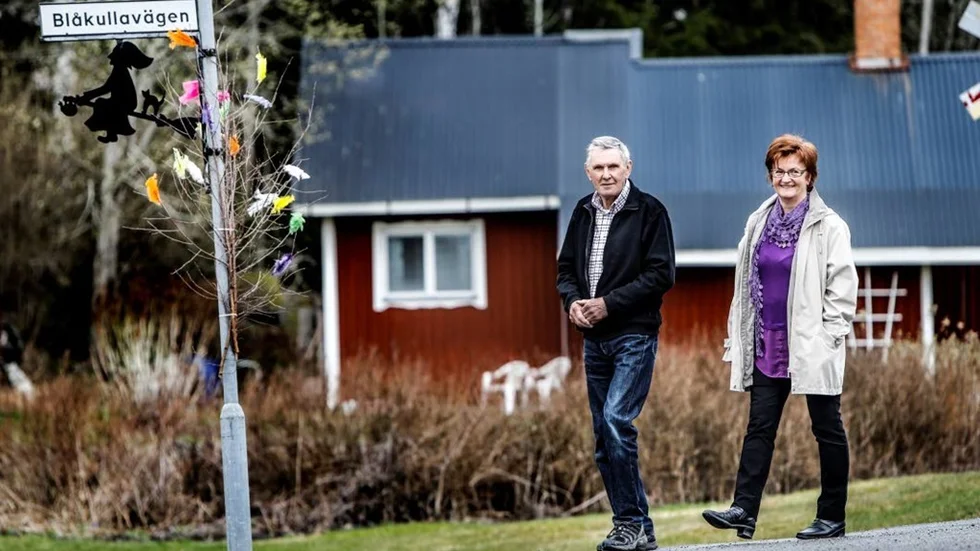 Hasse och Britt-Marie Löv pyntar traditionsenligt Blåkullavägen med färgglada fjädrar.