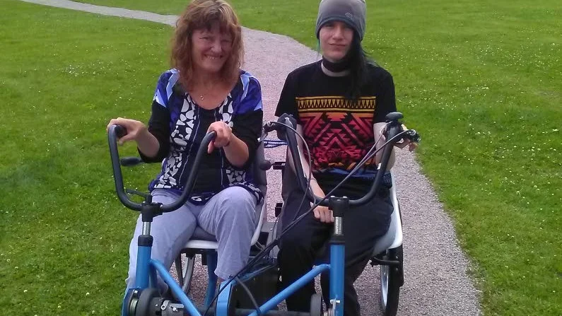 Maria med sitt barn på cykeltur.