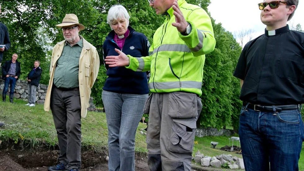 Visning av utgrävningen av biskopsgården. Joakim Kjellberg berättar om gårdens uppbyggnad ärkebiskop Antje Jackelén, hennes make Heinz Jackelén (t v) och adjunkt Joel Ingmarsson.