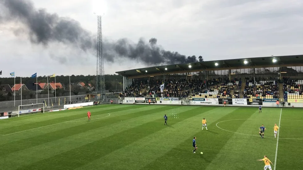 I brist på hetta på planen vändes publikens blickar mot den dramatiska branden.