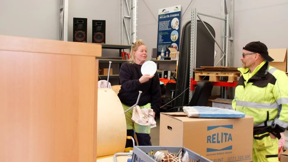 Maria Eriksson hojtar glatt till Pasi Virtanen som hjälpte henne hitta kassen med fat bland alla prylar i tältet med återanvändningsbara saker.