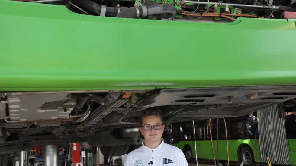 Teo Forsberg testar att gå under en buss i verkstaden.