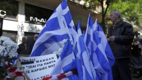 Grekiska flaggor vid den plats där Manolis Kantaris rånmördades, den händelse som kom att bli den utlösande faktorn för de omfattande attackerna mot invandrare i Aten.