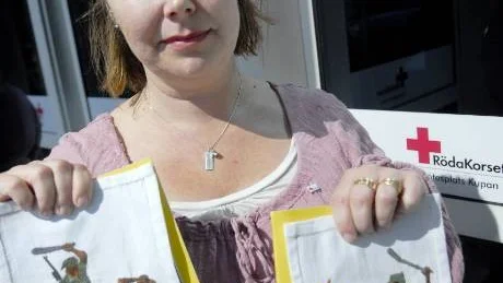 ÖVERGREPP MOT KVINNOR. Madeleine Lundberg håller upp fina broderier som kvinnor i Kongo har gjort. Broderierna visar hur kvinnor blir utsatta för våld och övergrepp av beväpnade män.
