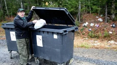 GILLAR INTE NYORDNING. Birger Hansson, 76, Prinsnäs, gillar inte när sopkärlen vid husen tagits bort. Nu måste han färdas 1,3 kilometer för att bli iväg med soppåsarna. I bakgrunden en del av det som finns kvar när kommunen städat efter björnar som kalasat på sopor.