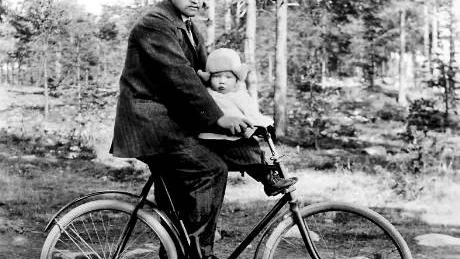 LITEN KNATTE. Här är Helmer Widlund bara en tvåårig knatte som får sitta på pappa Oscars cykel. Oscar var rådman och tapetserarmästare i Luleå. Sonen började på 30-talet samla fotografier för kommunens räkning. Det var han som lade grunden till det stora bildarkivet som i dag omfattar mer än en miljon bilder och negativ.