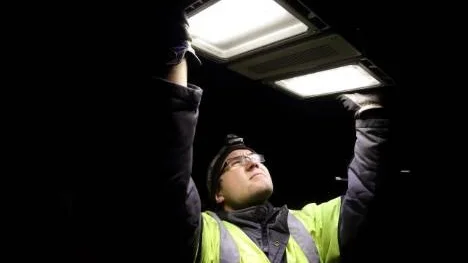 Tobias Westermark, installationselektriker på Nelab, i full färd med att montera en av alla lampor. Den nya armaturen består av två ljuskällor på vardera 60 watt.