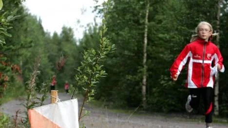 Hanna Lindmark på väg in mot mål, skuggad av mamma och lillebror. "Det är kul. Man får vara i skogen och lära sig att läsa kartor" säger åttaåringen som tränat orientering i två år.