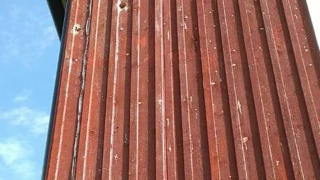 MASSOR MED HÅL. Här syns några av de stora hålen som hackspettarna gjort i gavlarna på Doris och Sven Tuveheds hus i Muodoslompolo.