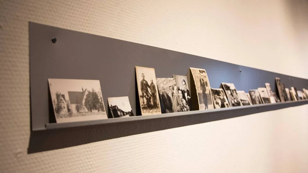 Överblivna. Längs vägen står bilder ur familjearkivet som är märkta "okända personer och platser".