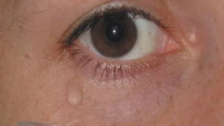 This undated handout photo provided by the journal Science shows a donor woman watching sad films in isolation, using a mirror to capture tears into a vial. If a crying woman's red nose isn't a big enough turnoff to a man, a surprising experiment found another reason: Tears of sadness may temporarily lower his testosterone level. (AP Photo/Science)