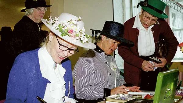 Febe Lindén och Britt-Marie Andersson från Eksjö tar ut en avgift av Anne-May Walfridsson från Edshult. Bakom syns ordföranden Ingegerd Westberg.