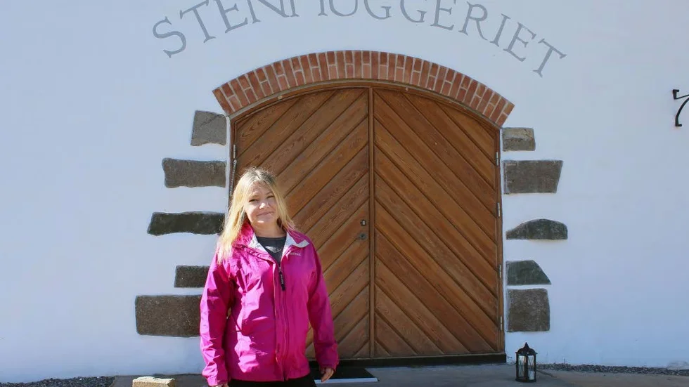 Vid porten. Anna Davidsson framför Stenhuggeriet i Gamleby, som byggdes nytt i gammal stil och invigdes hösten 2014.