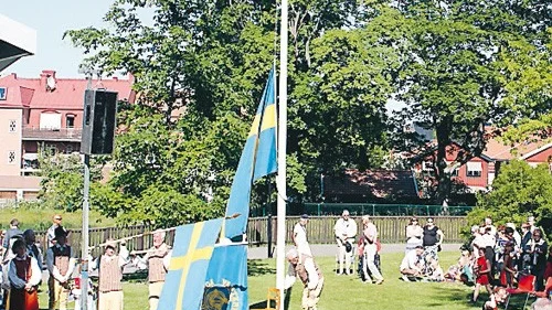 Medlemmar ur folkdanslaget hissar svenska flaggan och firandet kan börja.