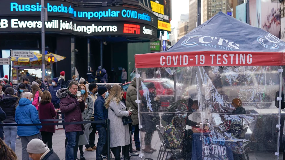 Människor står i kö för att testa sig för covid-19 på Times Square i New York under måndagen.