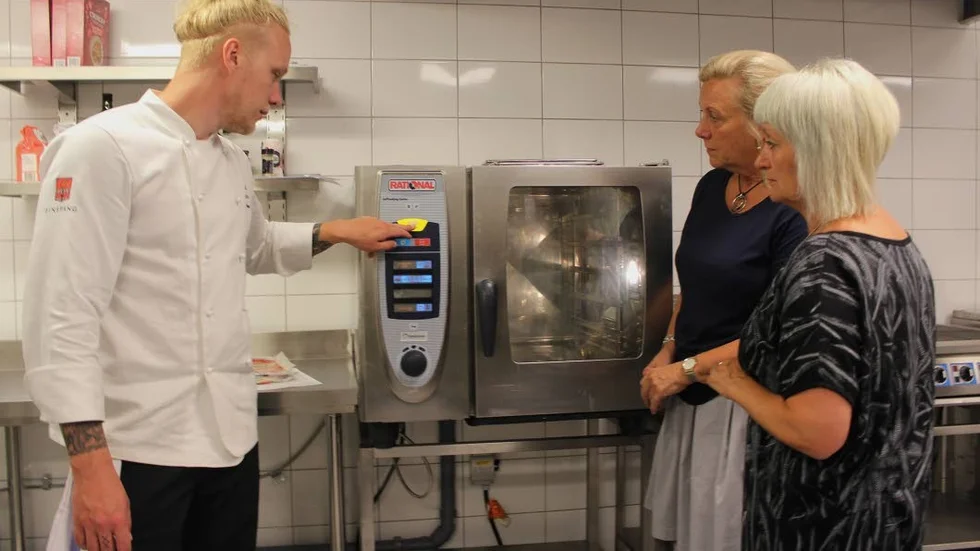 Johan Svensson, kock och lärare, visar en av ugnarna som finns i det nya utbildningsköket för utbildningsstrateg Ylva Svensson och integrationssamordnare Suada Talic.