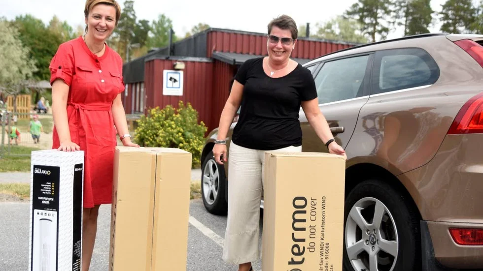 Nita Keljalic, strateg inom förskolan, och Carina Lövgren, förskolechef, på väg in till Lekeberga förskola med fläktarna som skänkts av Golv&Byggterminalan i Norrköping.