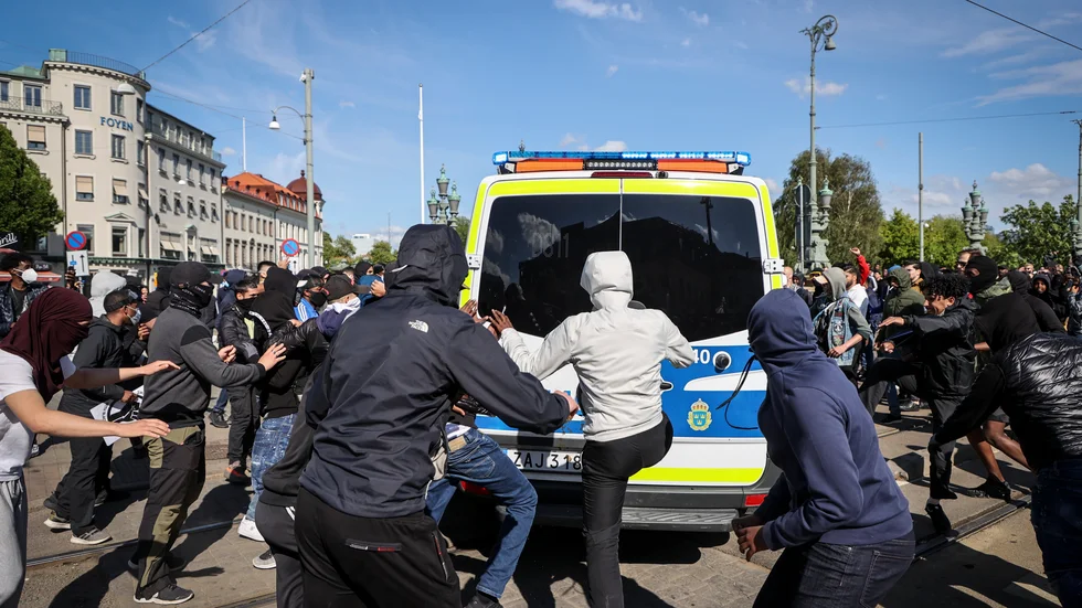 Maskerade personer attackerar en polisbil i samband med en demonstration för Black Lives Matter i Göteborg 2020.