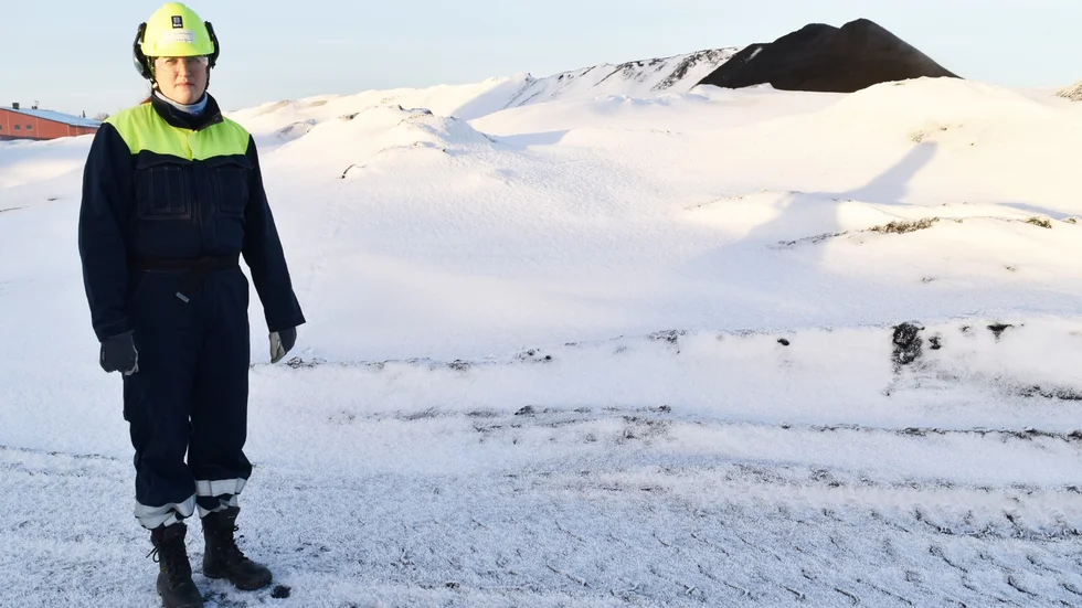 Problemet. Linn Andersson uppe på det cirka 20 meter höga och snöbeklädda berget. I bakgrunden körs nyproducerad järnsand upp, för än växer berget. Foto: Yvonne Rönngren.
