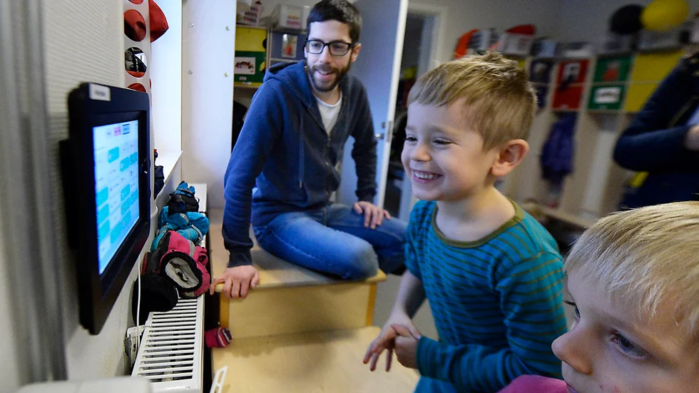 Leo Holmström, 4 år, och Tim Eriksson, 5 år, tycker att det är roligt att klicka in sig själva i närvarosystemet. I bakgrunden sitter förskolläraren Stefan Lindkvist. Foto: Roine Sandlén