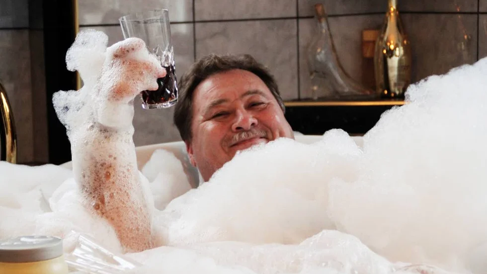 SKÅL. Leif-Ivan Karlsson njuter av livets goda som bubbelbad och en grogg i Kanal 5:s serie Svenska miljonärer.