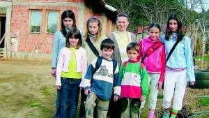 Mor och barn. Mirvete Kahrimani omgiven av sina sju barn. Laridona, Sala, Habibe, Marigona, Sadie, Altin och Sadri framför huset i byn Çabra. För dagen är alla uppklädda i begagnade kläder från Sverige.