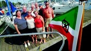 Glada båtfarare. Med egen flagga har en grupp från Nautiska klubben i Stockholm tagit sig till Västervik för ett Boat meet-besök. Från vänster står Mariana Rönnbäck, Tomas Ramén, Annika Tenser, Erik Lager, Christel Gunnarsson, Peter Ramén, Göran Gunnarsson och Rolf Tenser.  Foto: ANDERS LILJEGREN