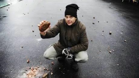 Torbjörn Bergerum, platschef för Byggmax i Västervik, håller upp en av stenbumlingarna som kom inflygandes på området när en sprängning vid Allén gick fel.