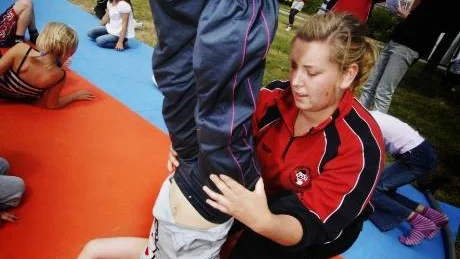 Cirkustränare Alexandra Andersson hjälper Lisa Bladström att stå på händer.