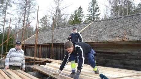 Spåntaket till Oxebo vattensåg är så dåligt att det måste täckas med ett plåttak för att rädda byggnaden. Här arbetar Jan-Inge Pettersson, Erik Larsson och Gustav Wirengård med takläkten. Foto: Hans Brandin