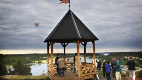 Nu är lusthuset med Bertil Dolks vimpel på invigt. Flera papperslyktor släpptes upp på sommarhimlen till tonerna från en näverlur. Foto: Anders Steiner