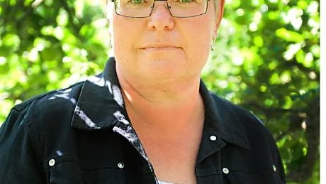 Eva Halldén under äppelträder i sin trädgård i Skedshult. Foto: Magnus Karlsson.