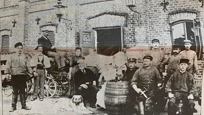 Personalen på Vingåkers bryggeri vid slutet av 1890-talet. Från vänster Karl Eriksson, själv på väg att dra 300 flaskor öl till hotellet, bokhållare Larsson, "Bryggar-Hasse" kallad, ölutkörare Widén, sköljerskorna Wiborg och Gertrud Pihl. Sittande disponent Rinman, hotellinnehavarinnan fröken Tideman, stationsskrivare Dahlberg, Karl Bergström och bryggmästaren Karl Edqvist. De tre männen som ses stående till höger är Karl Nilsson, Karl Ekberg och Emil Persson.