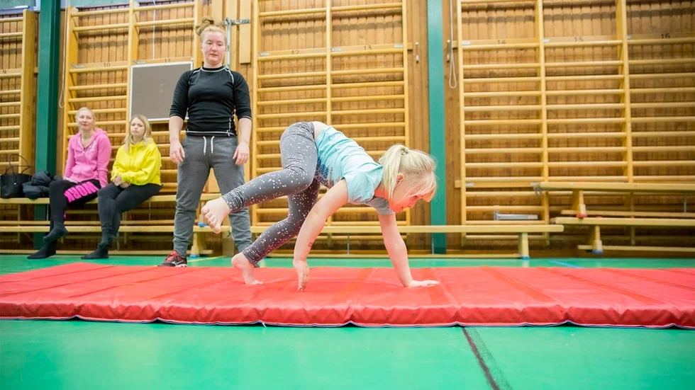 Melinda Larsson går på alla fyra och bakom står instruktör Elsa Näslund.