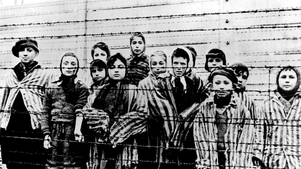 Sovjetiska trupper möttes av överlevande bakom taggtråden som inhägnade Auschwitz-Birkenau, den 27 januari 1945.