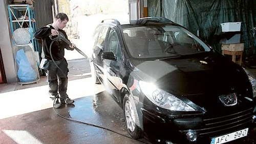 Glänser som ny. Hemtjänstens svarta Peugeot får en välbehövlig genomgång med högtryckssprutan av Johannes som jobbar med den nya avdelningen inom intraprenaden Framsteget.