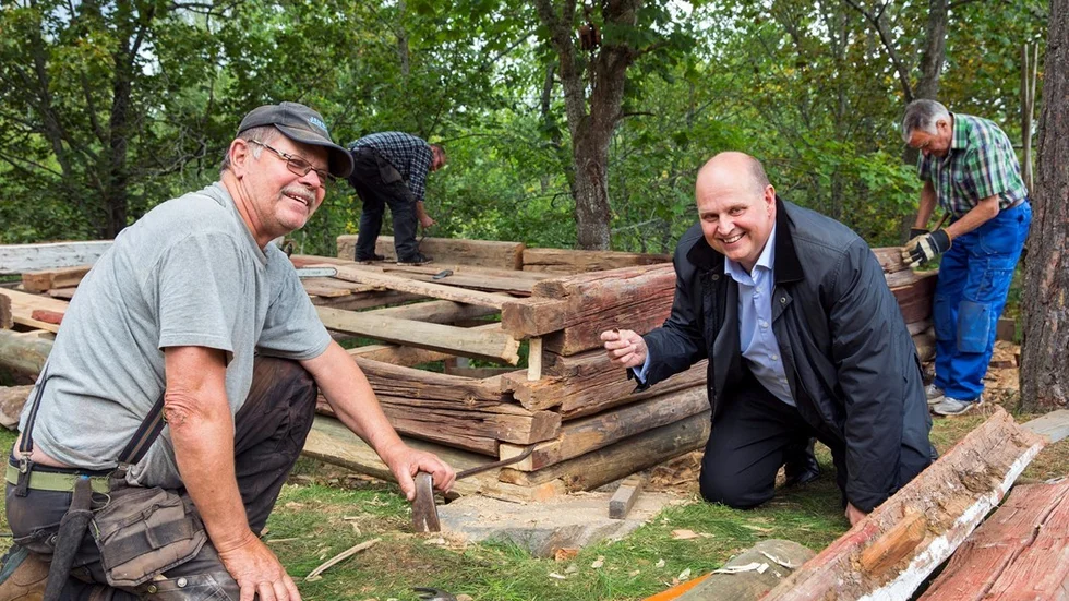 Tradition med mynt. Johan Widerström, vd för en bank med kontanter, får äran att lägga ett mynt mellan det första och andra lagret med timmer. Myntet är präglat 2016, det år som projektet med att flytta fähuset inleddes.