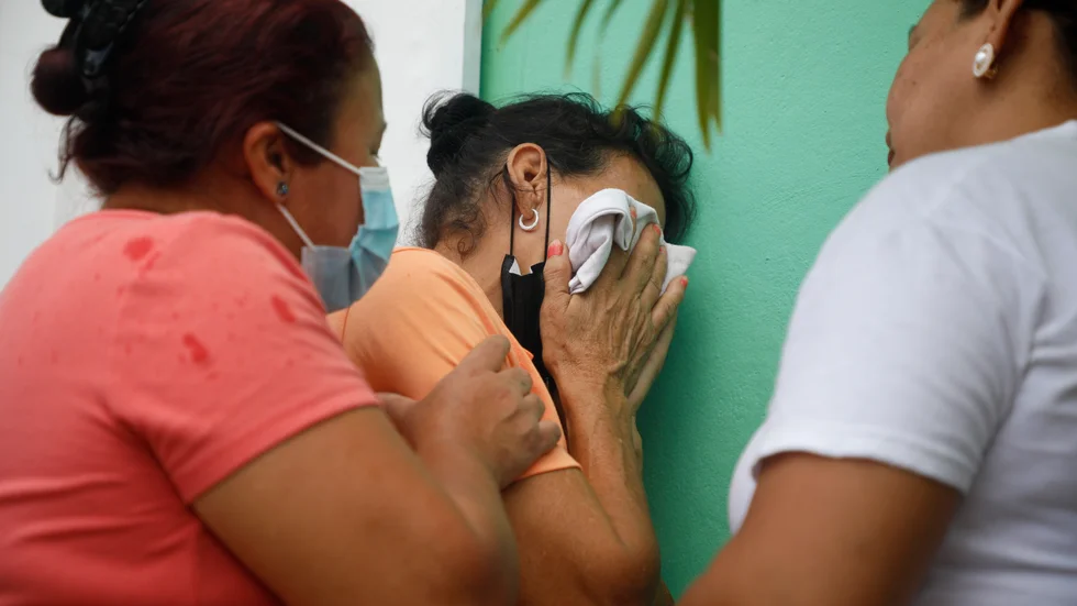En kvinna vars släkting attackerats inne i kvinnofängelset i Honduras tröstas medan hon väntar på besked om hennes släkting är en av de 46 som dödats i gängattacken.