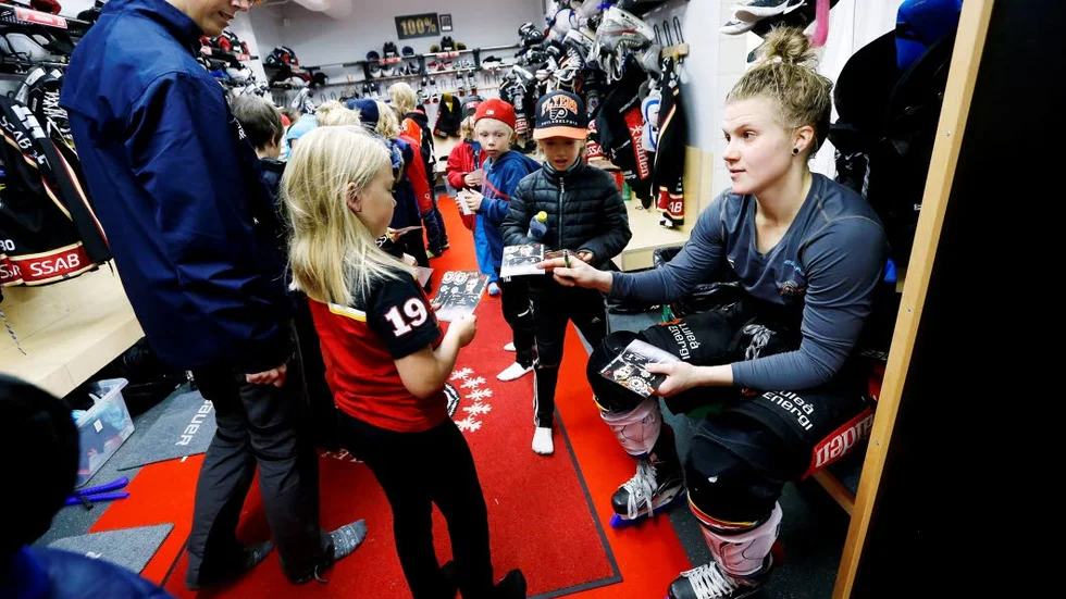 Hockeyspelaren Johanna Fällman träffar fans i omklädningsrummet. Kanske är flickan en blivande hockeystjärna?
