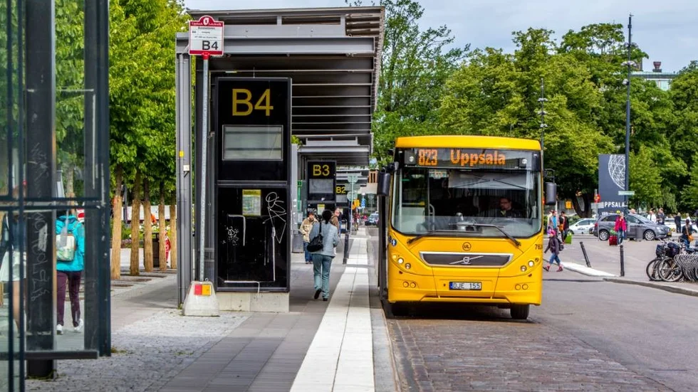 genrebilder:  Upplands lokaltrafik,  gul buss vid centralstationen.