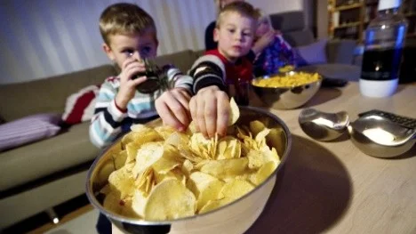 Familj har fredagsmys med chips och osbågar.
