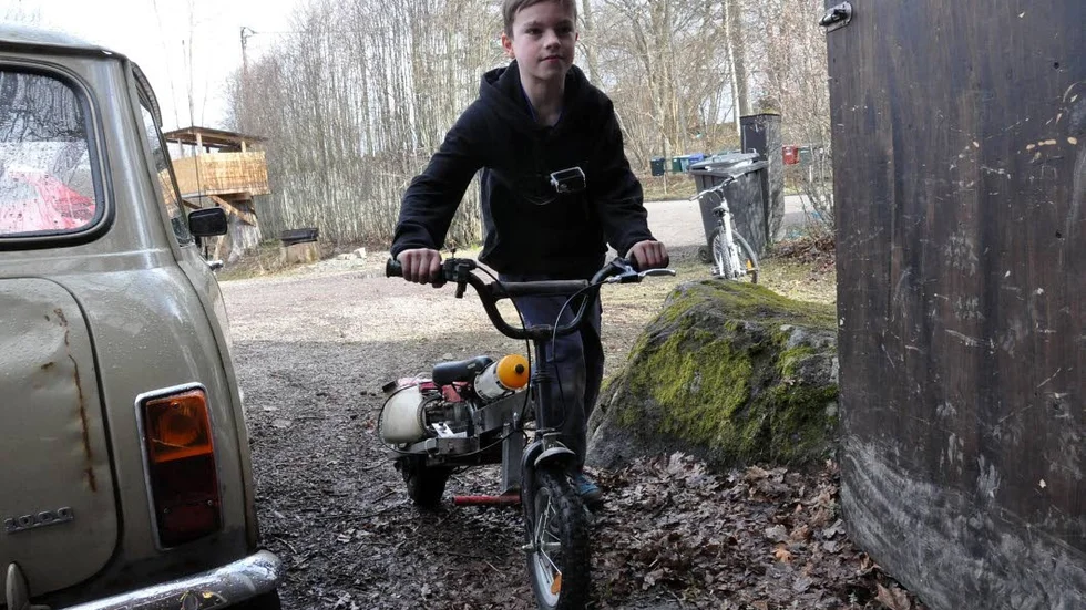 Simon Ring, 11, rullar in den ombyggda barncykeln – som numera fungerar som moped – i garaget.