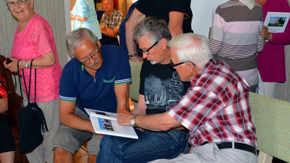Stort intresse. Lars Rönnblom, Per-Göran Karlsson samt Sture Bodén studerar innehållet i Mårtensboda byabok. Foto: Peter Eklund.