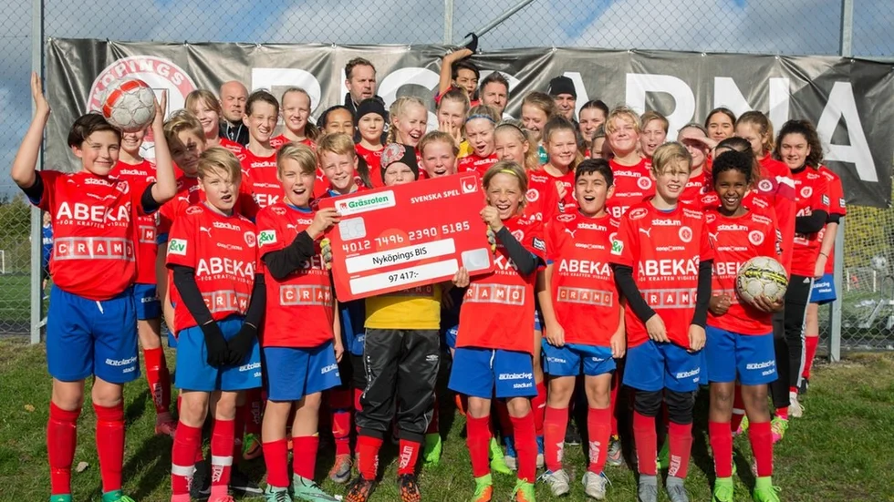 Nyköpings BIS F-04/05 och P-05 framför sina ledare Petter Westberg, Lars Glysing, Pepito Padron och Andreas Söderström jublar med ett kreditkort från Svenska Spels Gräsroten som de tilldelats.